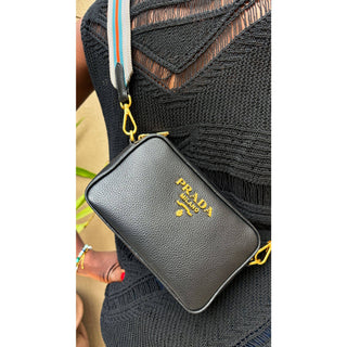 Prada camera bag in black leather with gold hardware and webstrap