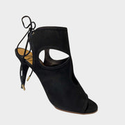 Side profile close-up of an Aquazzura Sexy Thing 85 sandal in black suede, showing the teardrop cut-outs and slim stiletto heel.