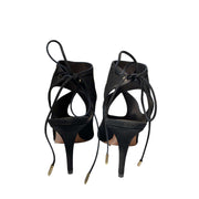 Heel view of Aquazzura Sexy Thing 85 black suede sandals from behind, focusing on the curved heel counter and rear ankle tie closures.
