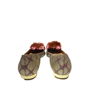 Heel view of Aquazzura Powder Puff pink embroidered flats, highlighting the small gold-toned block heel and the pink textile pompom on the vamp.