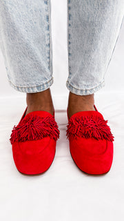 Close-up on-foot view from the front of the Aquazzura Wild Thing red suede loafers, showcasing the full fringe texture.