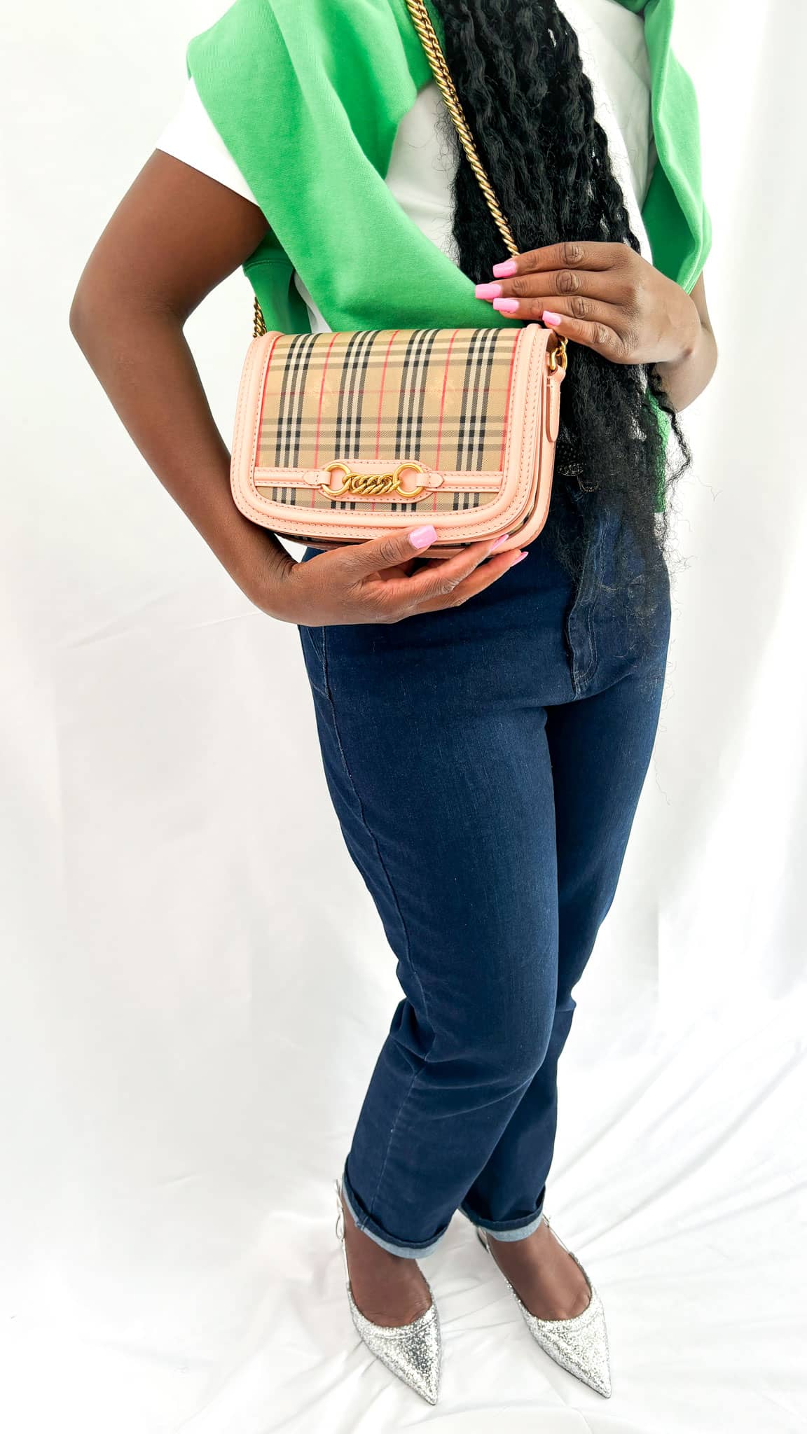 Front view of a model wearing the Burberry Link check bag, showcasing its elegant day-to-night styling silhouette.