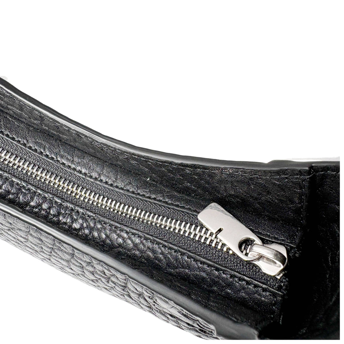 Close-up of the silver-tone metal zipper closure and pull tab on the black leather Burberry Chess bag.