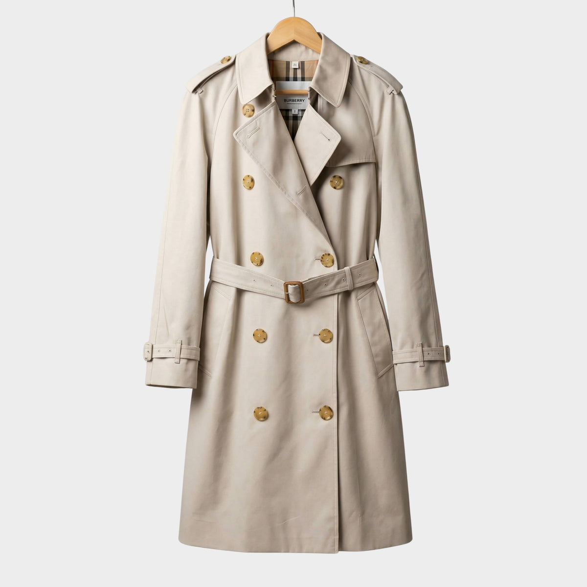 Front view of the classic Burberry Hillington trench coat in beige cotton gabardine displayed on a wooden hanger.