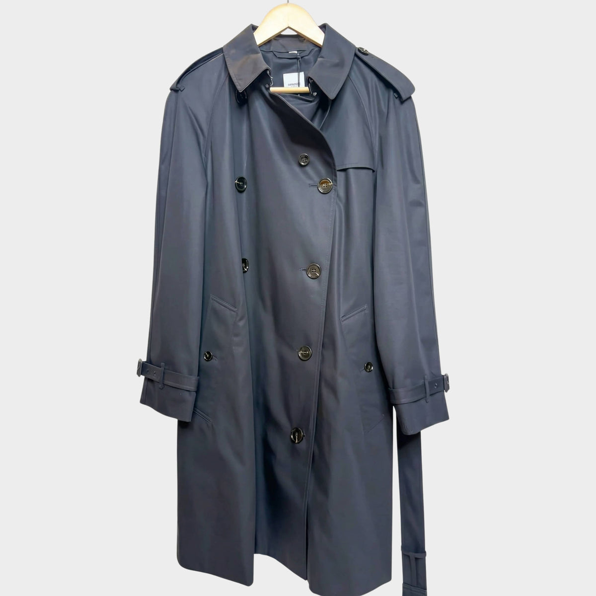 Front view of the classic Burberry Hillington trench coat in black lightweight cotton gabardine on a wooden hanger.