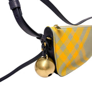 Three-quarter side angle of the Burberry Shield shoulder bag in yellow checkered canvas and black leather.