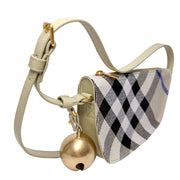 Side angle view of the Burberry Shield checkered canvas shoulder bag, highlighting the dangling gold-tone bell charm.