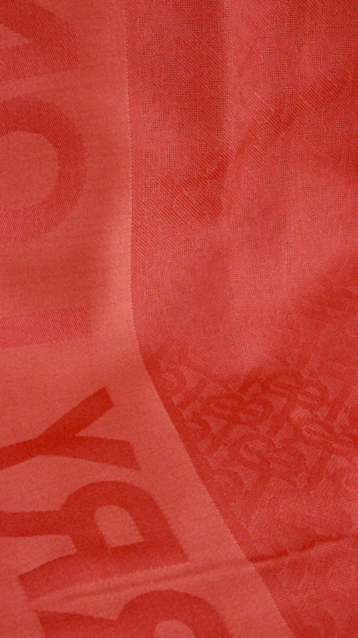 Detailed view of the red Burberry monogram scarf showcasing the tonal TB graphic weave.