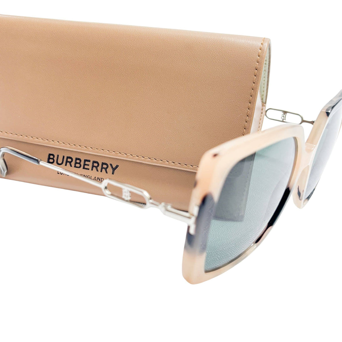 Angled view of Burberry tortoiseshell sunglasses styled next to the classic beige Burberry protective eyewear case.