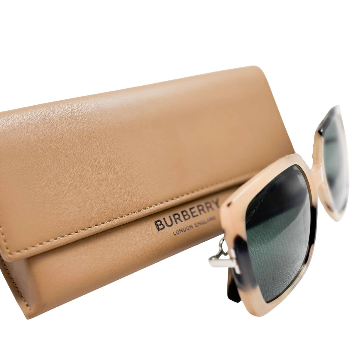 Burberry square frame sunglasses in tortoiseshell acetate resting on an open tan leather luxury sunglasses case.