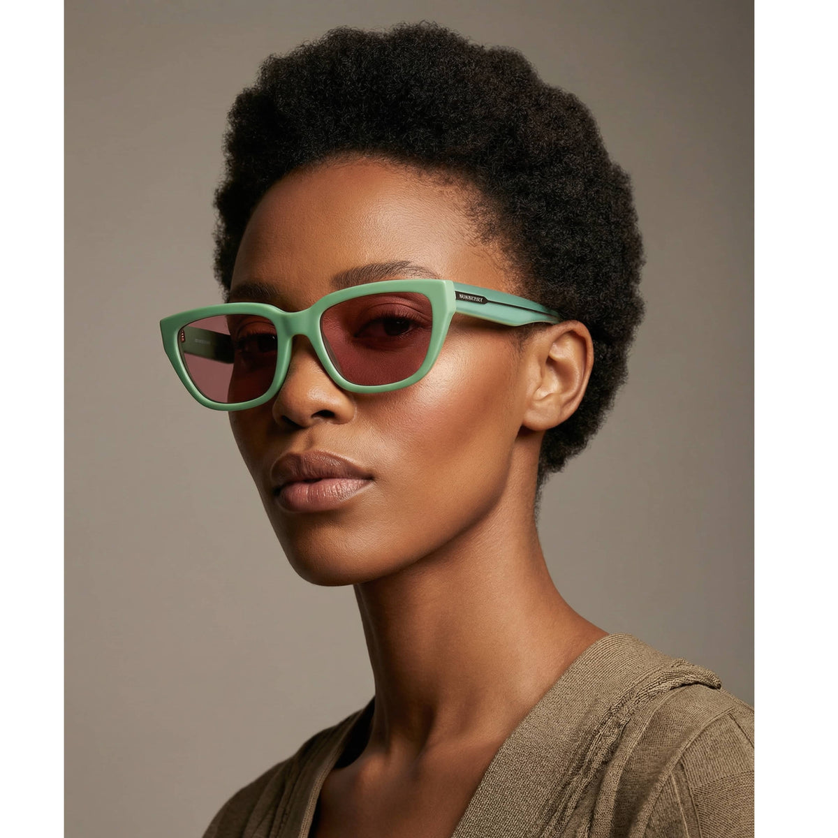 Model wearing mint green Burberry rectangle designer sunglasses styled as a contemporary luxury fashion accessory.