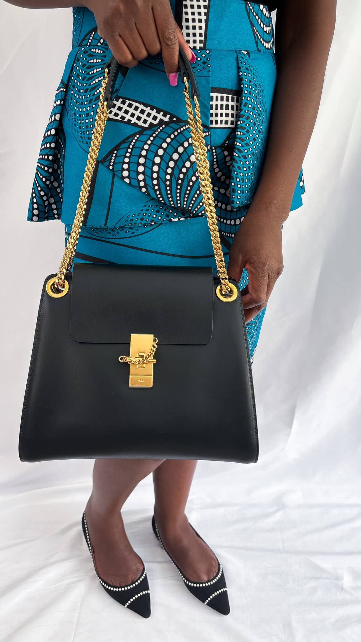 Model holding the black Chloé Annie handbag, highlighting its sharp, structured silhouette and modern minimalist design.