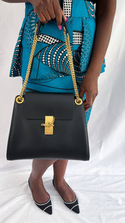 Model holding the black Chloé Annie handbag, highlighting its sharp, structured silhouette and modern minimalist design.