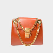 Front close-up view of the brown Chloé Annie shoulder bag in shiny calfskin, showcasing its sophisticated gold turn-lock with chain detailing.