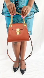 Full-length view of a model carrying the tan Chloé Annie leather bag, demonstrating its medium size and elegant hang.