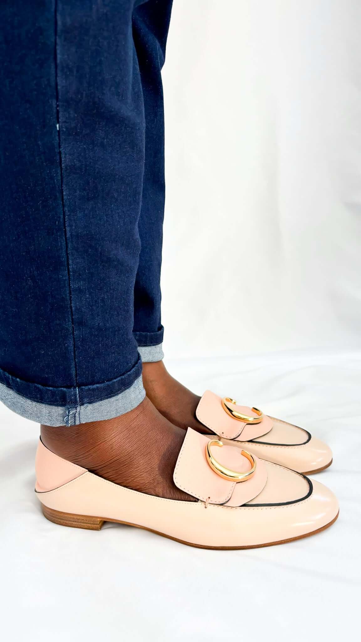 Side angle on-foot view of the Chloé C pink patent leather loafers, showing the classic slip-on flat silhouette