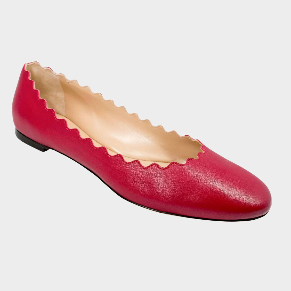 Side profile close-up of a Chloé Lauren ballet flat in raspberry sorbet pink leather, showcasing the iconic scalloped edging and round toe.