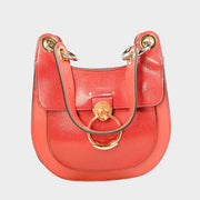 Front close-up view of the Chloé Tess shoulder bag in vibrant red calfskin leather, showcasing the signature gold-toned ring hardware and top handle.