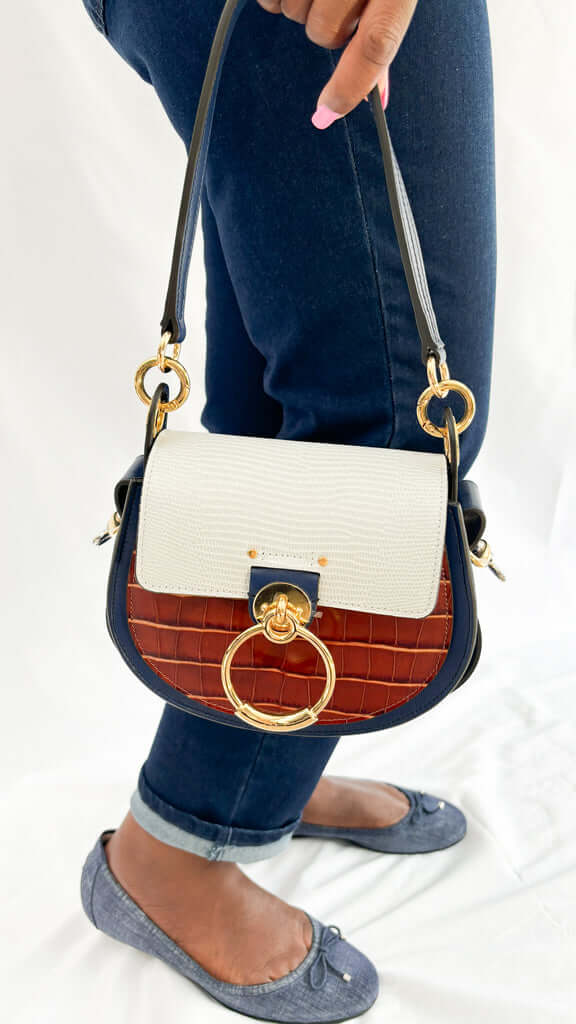 Side profile angle of the Chloé Tess shoulder bag showcasing its croc and lizard embossed leather textures and gold-tone side attachment.