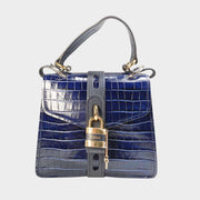 Front close-up view of the Chloé Aby Day Shoulder Bag in navy blue croc-embossed calfskin leather, showcasing the gold-toned heritage padlock.