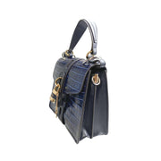 Right side three-quarter profile of the Chloé Aby Day navy blue leather bag, showing the softened structural angles and gold key accent detail.