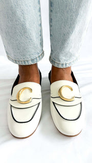 Front perspective wearing shot of the white Chloé C patent leather loafer flats, focusing on the golden C hardware accent.