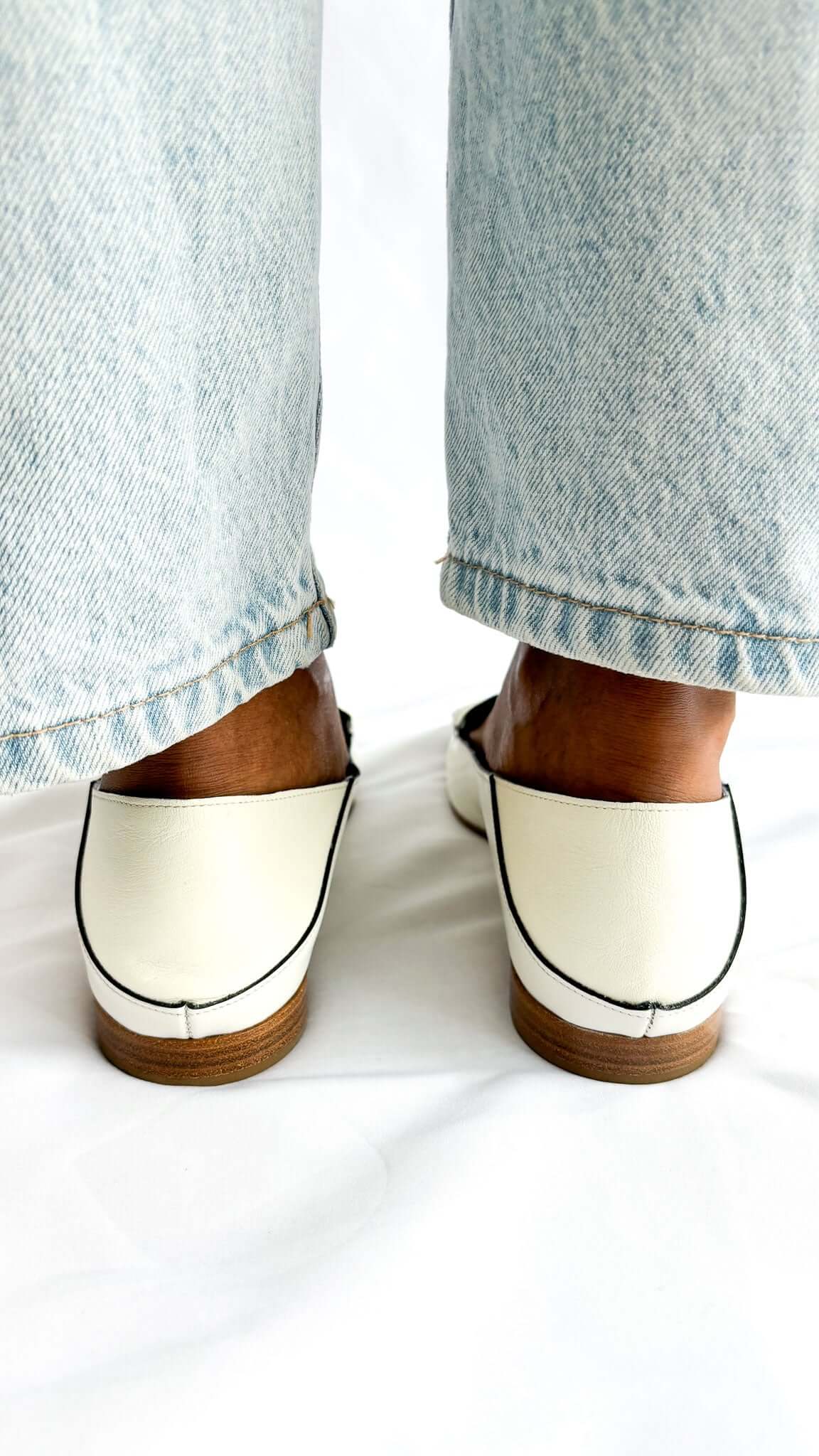 Front perspective view of a pair of Chloé C white patent leather loafers against a white background, highlighting the symmetrical silhouette.