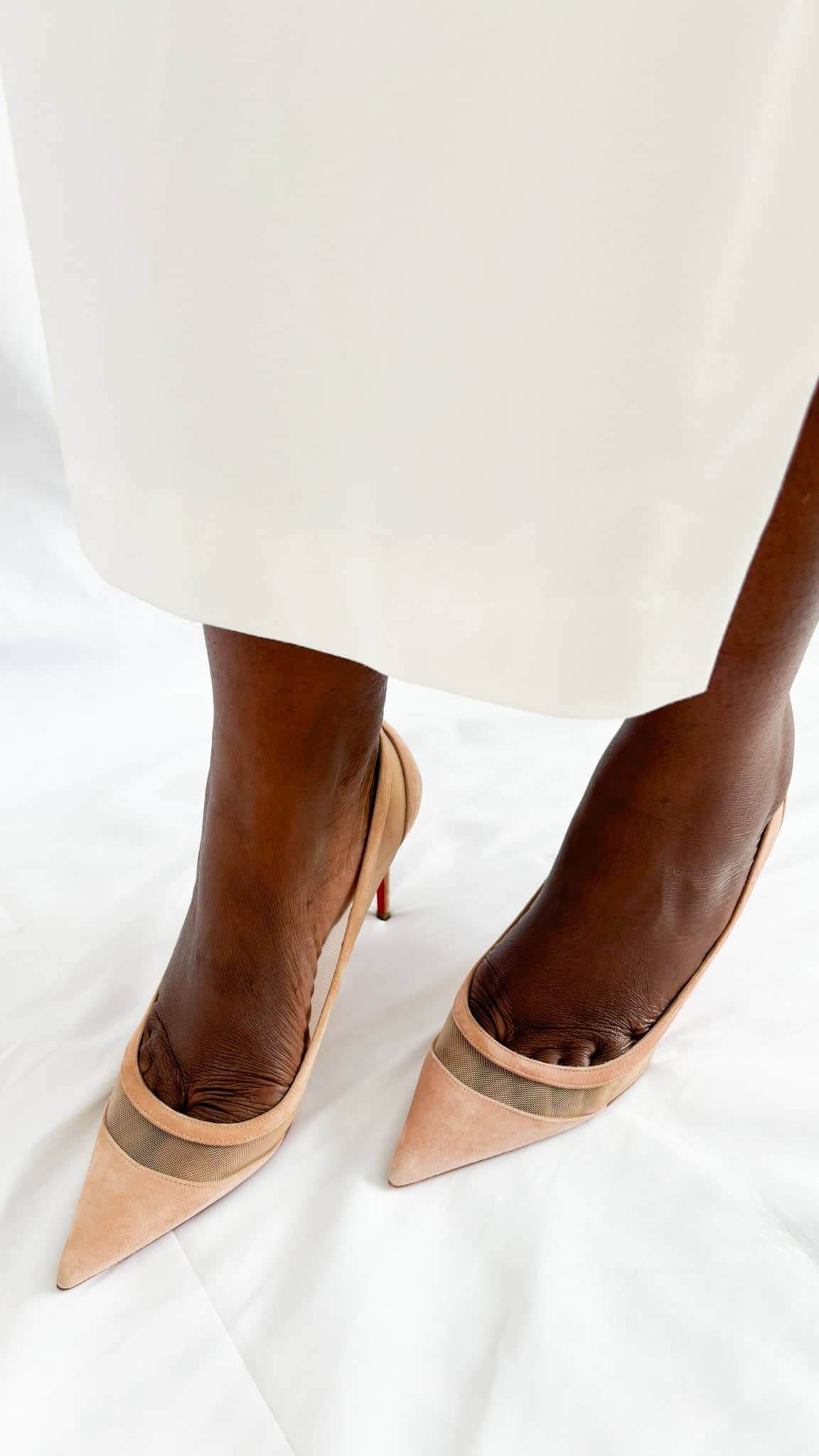 Top-down perspective wearing shot of a pair of dusky pink suede Christian Louboutin Galativi 90 pumps.