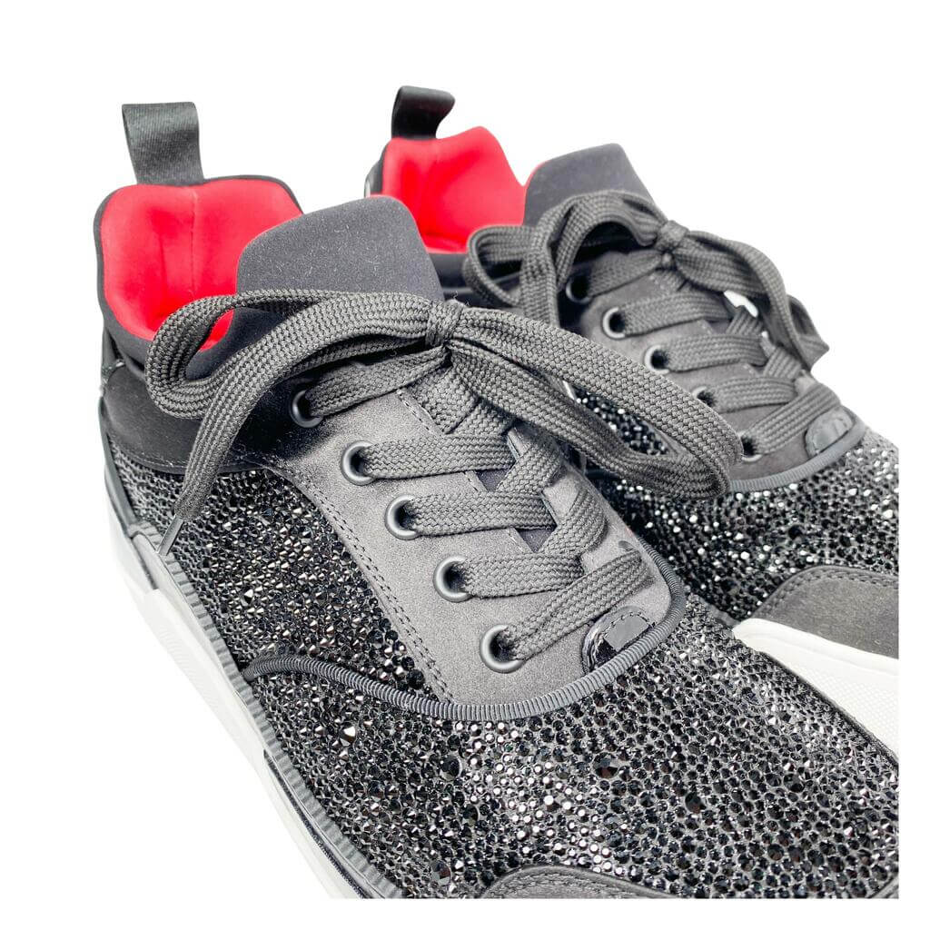 Three-quarter studio perspective of both Christian Louboutin Aurelien black and white low-top sneakers placed together against a clean background.