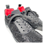 Three-quarter studio perspective of both Christian Louboutin Aurelien black and white low-top sneakers placed together against a clean background.