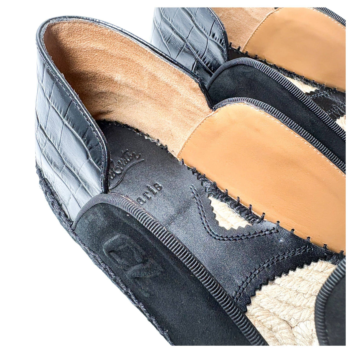 Macro detail shot of the Christian Louboutin Varsi Espadon showing the intricate connection between the black suede upper and the woven jute midsole.