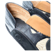 Macro detail shot of the Christian Louboutin Varsi Espadon showing the intricate connection between the black suede upper and the woven jute midsole.