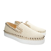 Side perspective studio view of a pair of pink studded Christian Louboutin espadrilles positioned together against a white background.