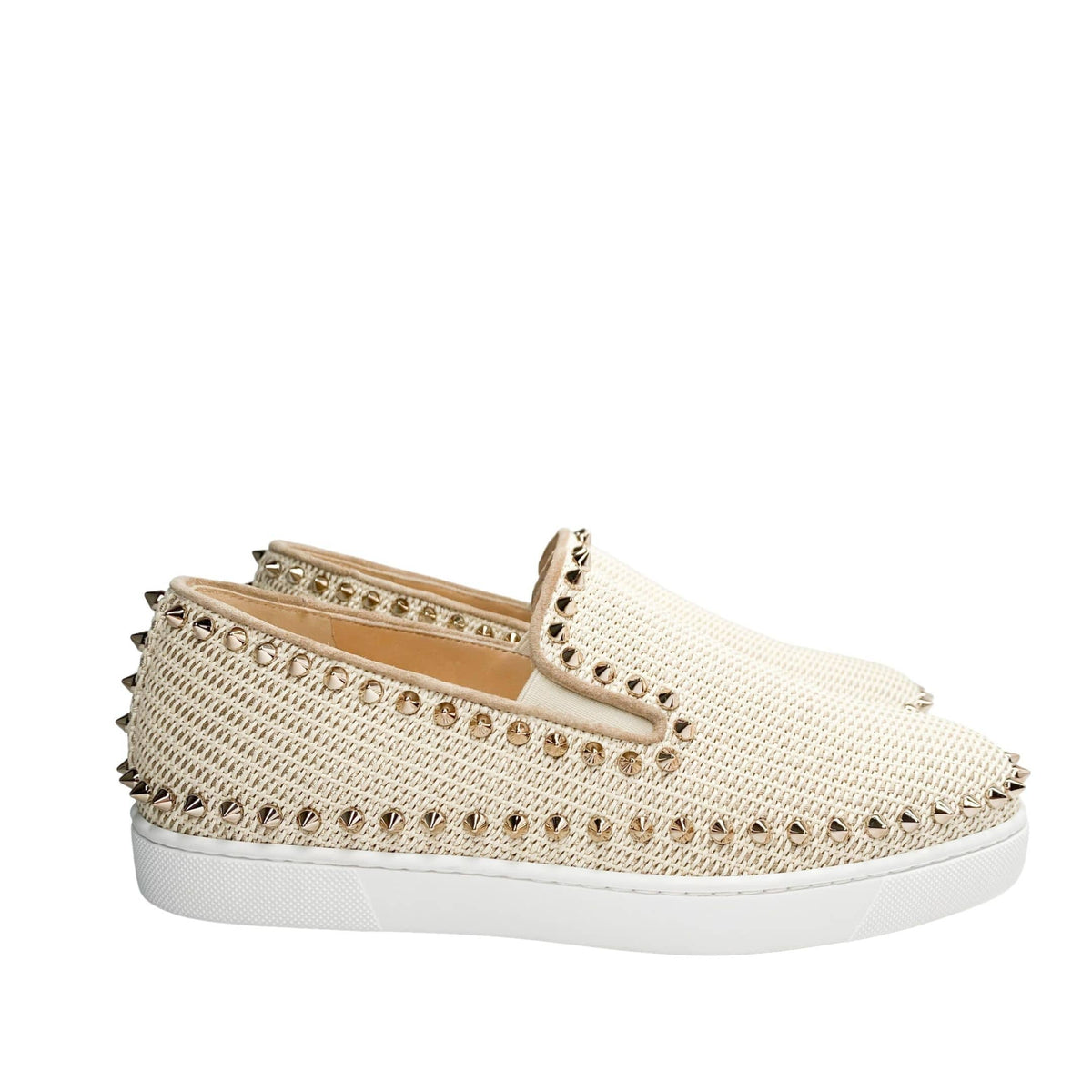 Full horizontal side profile of a single Christian Louboutin pink woven canvas espadrille flat, focusing on the golden spike collar detailing.