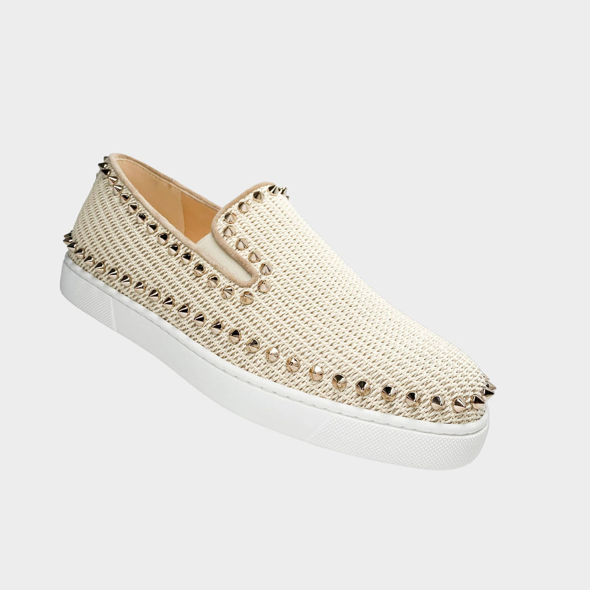 Side profile view of a Christian Louboutin Boat woven espadrille in pastel pink canvas, showcasing the signature gold pyramid studs along the trim and clean white midsole.