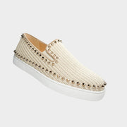 Side profile view of a Christian Louboutin Boat woven espadrille in pastel pink canvas, showcasing the signature gold pyramid studs along the trim and clean white midsole.