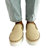 Symmetrical front angle on-foot view of a model wearing the pink canvas Christian Louboutin studded slip-on espadrilles.