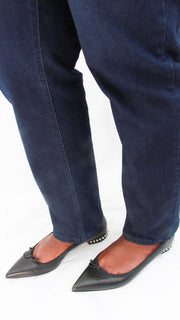 On-foot side perspective of a model wearing black leather Christian Louboutin Hall flats, styled with dark navy trousers.