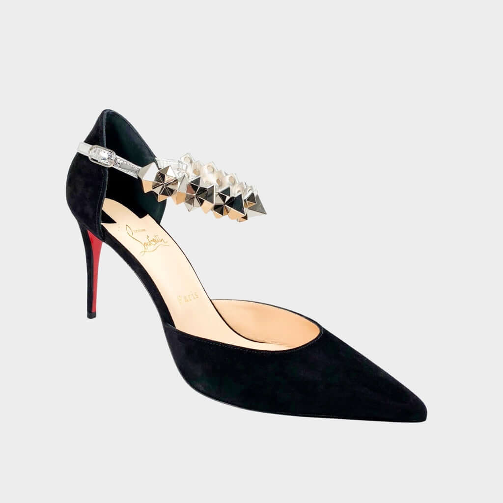 Side profile close-up of a Christian Louboutin Planet Chic 90 pump in black suede, showcasing the rock crystal-embellished ankle strap and sleek stiletto heel.