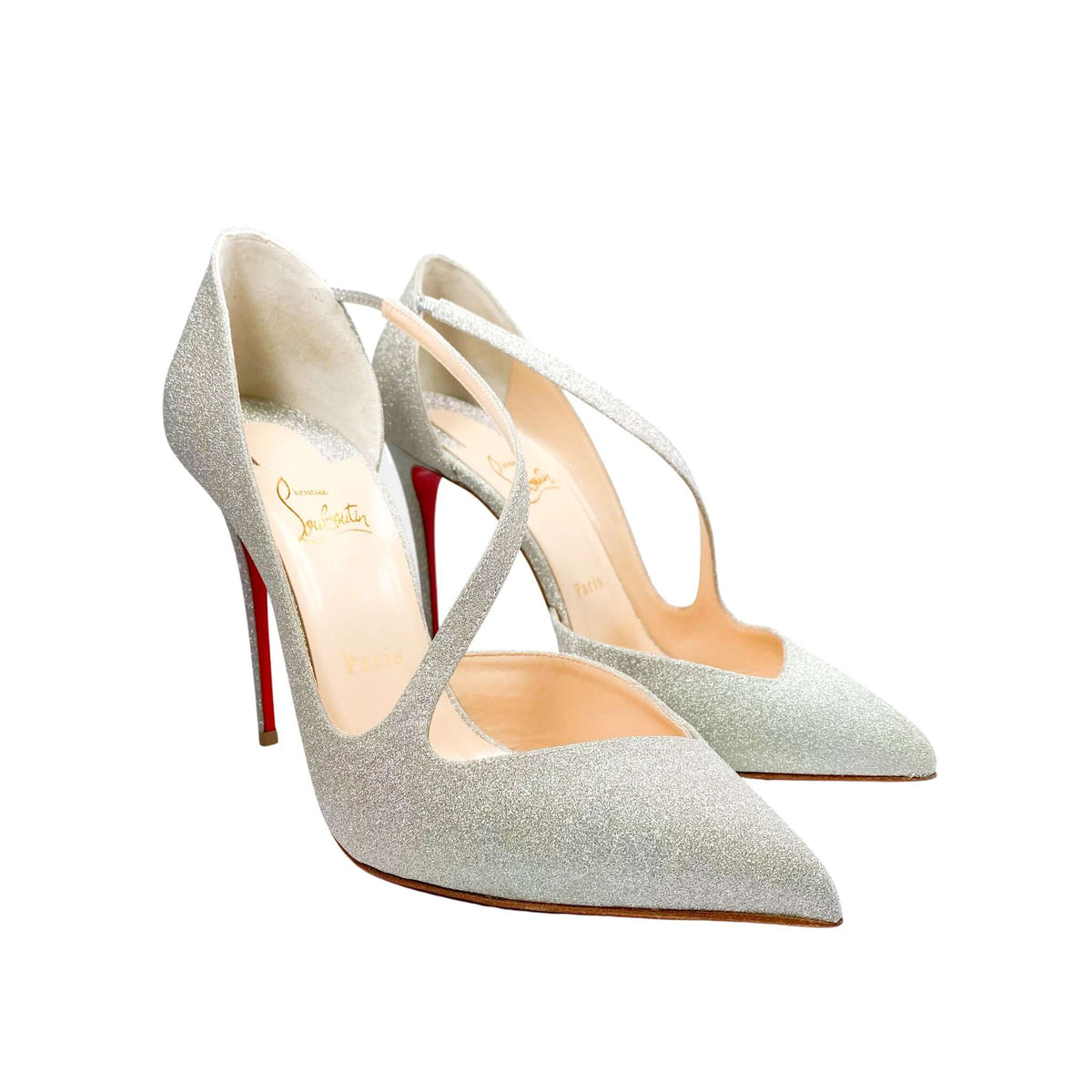 Side perspective studio shot of a Christian Louboutin Jumping Glitter 100 pump against a white background, highlighting the low-cut silhouette and curved elastic top strap.