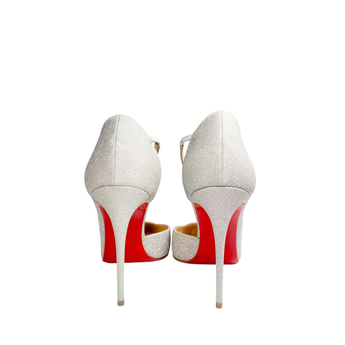 Rear view of a pair of Christian Louboutin Jumping Glitter 100 pumps from behind, focusing on the sleek 100mm stiletto heels and iconic red bottom soles.