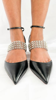 Symmetrical front perspective shot of a model wearing the black leather and clear PVC Christian Louboutin Levita 55 heels.