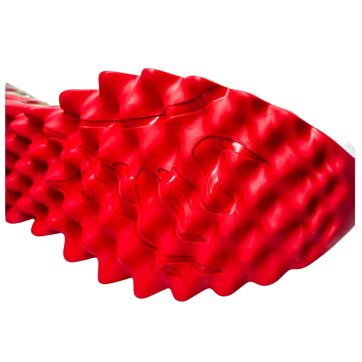 Angled close-up of the Christian Louboutin Loubishark textured red rubber outsole, emphasizing the geometric grip and sculptural shark-tooth shapes.