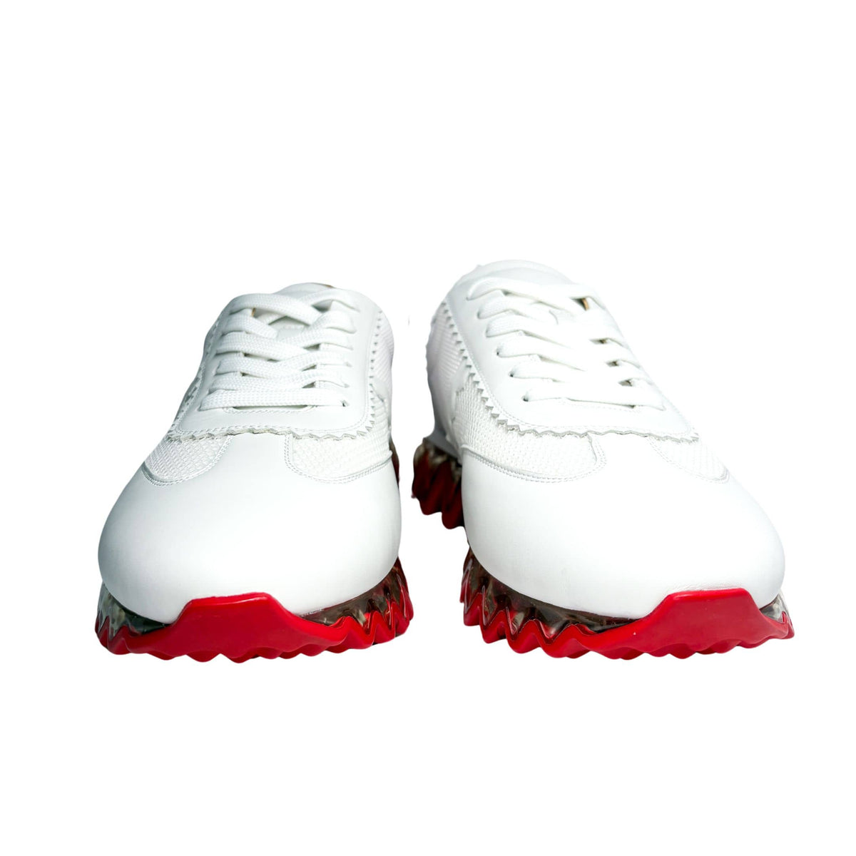 Front studio perspective of a pair of white leather Christian Louboutin Loubishark sneakers against a white background.