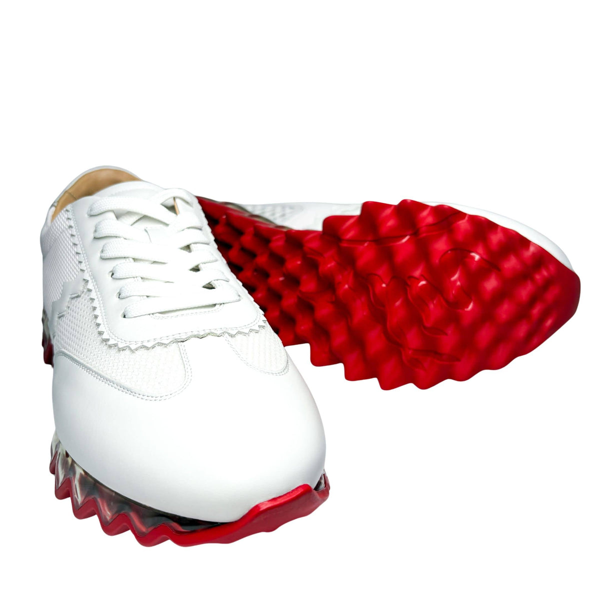 Bottom view of the Christian Louboutin Loubishark sneaker outsole, displaying the signature scarlet red rubber tread pattern.