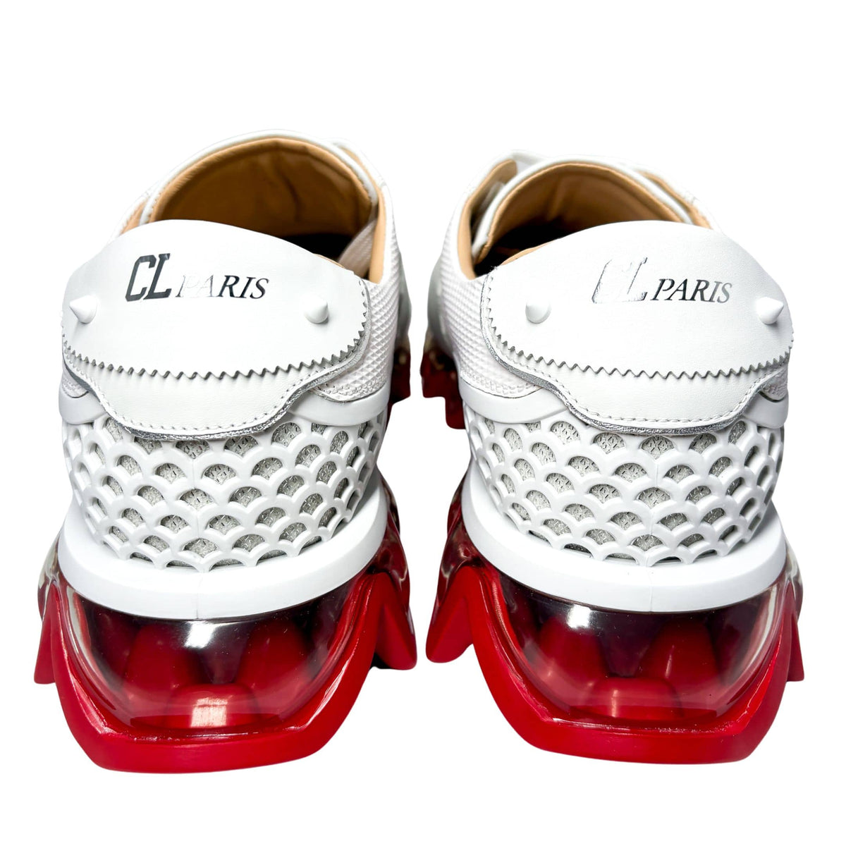 Rear view of a pair of Christian Louboutin Loubishark sneakers from behind, focusing on the caged lattice heel cage and translucent red accents.