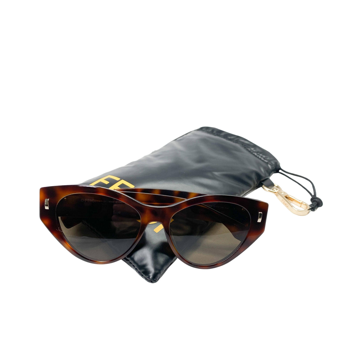 Fendi First cat-eye sunglasses resting in front of their included black protective designer pouch.