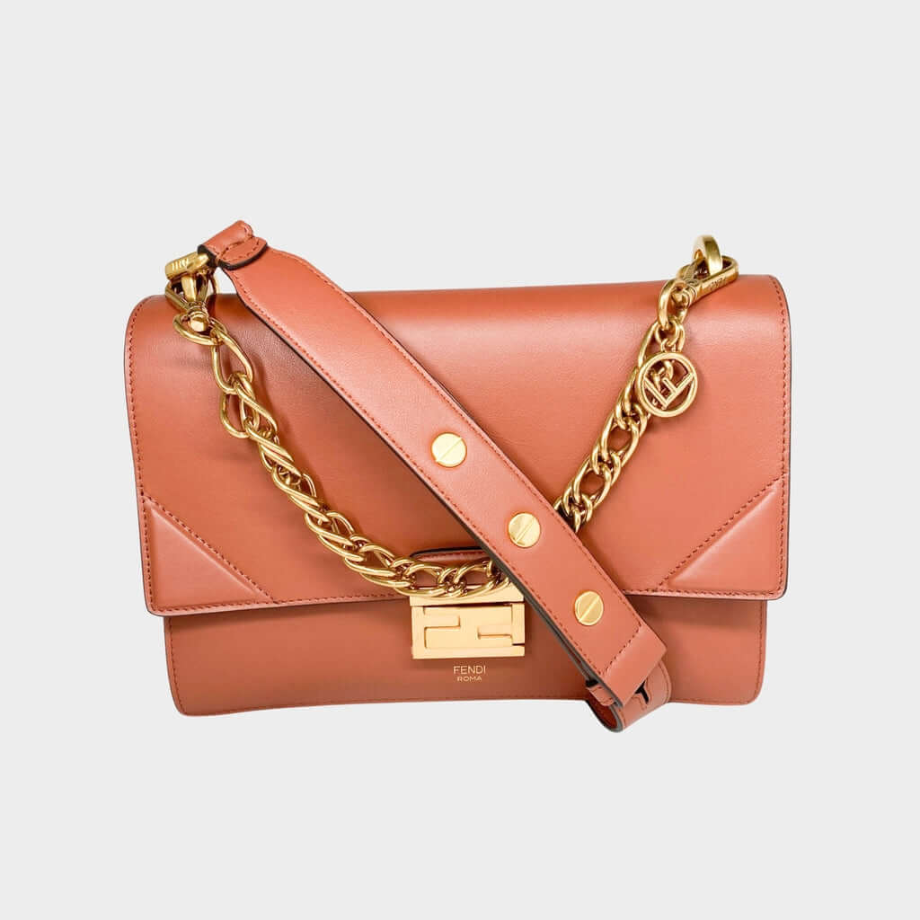 Front view of the luxury Fendi Kan U shoulder bag in brown calf leather, highlighting its gold-tone chain trim and geometric flap.