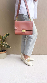 Side profile view of a model wearing the brown Fendi Kan U bag, showcasing its size, hang, and adjustable shoulder strap.