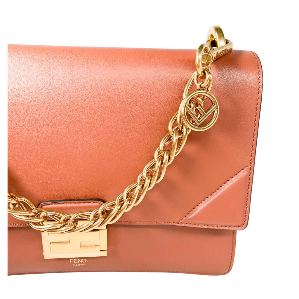 Detailed close-up of the iconic gold-tone FF press stud fastening and embossed corners on the Fendi Kan U bag.